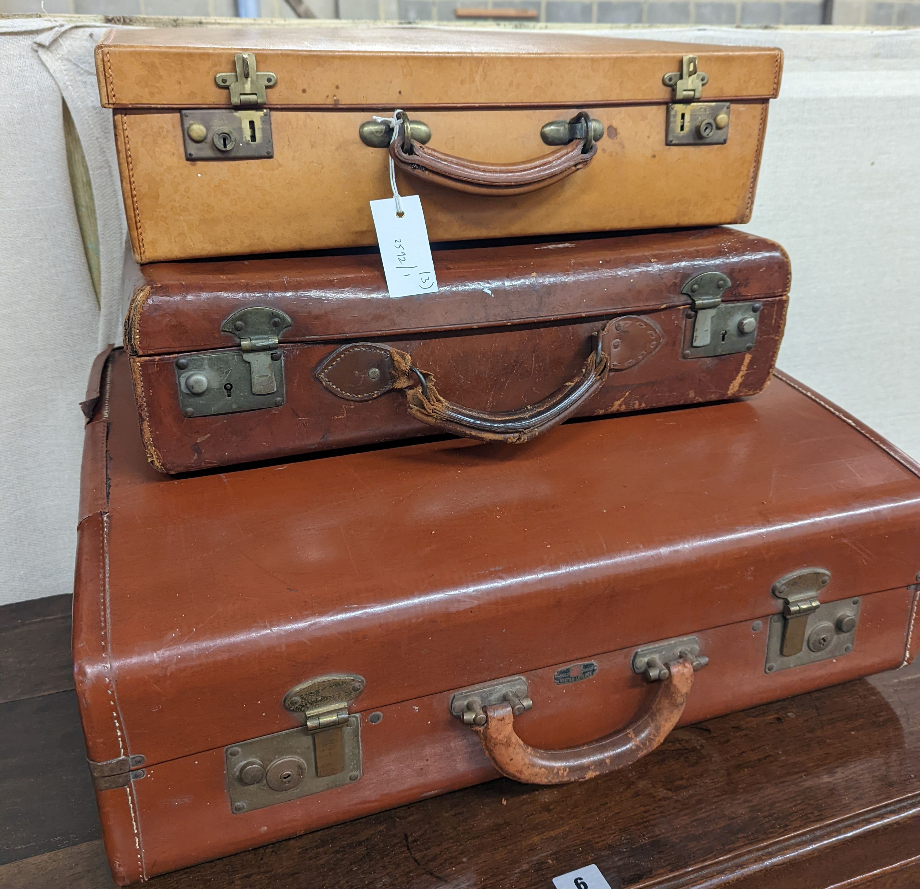 A vintage tan leather case, marked 'Tom Hill SW1' together with two other vintage cases, largest width 61cm, depth 46cm